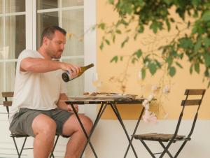 a man sitting at a table holding a bottle of wine at Quinta Amarela - B&B in Nazaré
