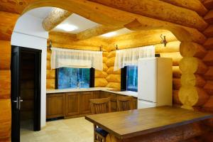 a kitchen with a table and a white refrigerator at Mi Chalet - Poiana Izvoarelor in Vatra Dornei