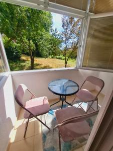 two chairs and a table in a room with a window at Urban Elegance Apartment Sarajevo in Sarajevo