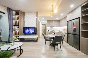 a living room with a table and chairs and a tv at VINHOMES GRAND PARK QUẬN 9 Căn hộ LUXURY MASTERI CENTRE POINT in Gò Công