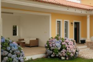 two flowering bushes in front of a house at Quinta Amarela - B&B in Nazaré