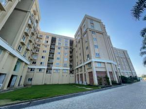 a large apartment building with a lawn in front of it at 2bed 2bath 2AC kitchen , Puri , Near Beach, Homestay at Ananya Palm Beach Apartment in Puri