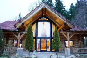 a log cabin with a large window at Mi Chalet - Poiana Izvoarelor in Vatra Dornei