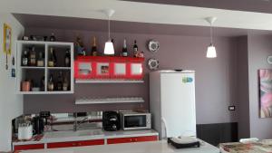 a kitchen with red cabinets and a white refrigerator at Vila Family in Cricova