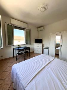 a bedroom with a bed and a desk and windows at Locanda Casa Ascari in Nonantola