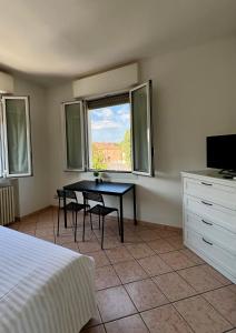 a bedroom with a table and chairs and a window at Locanda Casa Ascari in Nonantola