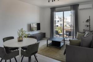 a living room with a table and a couch at Lithos Modern Flat by Staycom in Paphos City