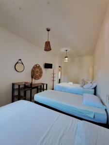 a room with two beds and a tv in it at Pousada Pipa Bela in Pipa +61 photos