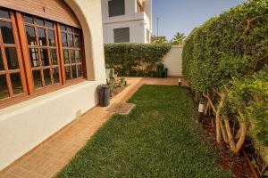 a house with a lawn next to a building at Spacious villa in Founty, beach side 40m front Sofitel in Agadir