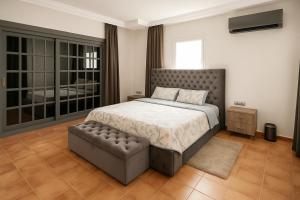 a bedroom with a large bed and a tufted foot board at Spacious villa in Founty, beach side 40m front Sofitel in Agadir