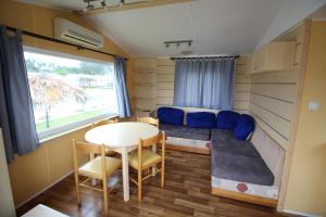 a tiny house with a table and a couch at Land's Hause Bungalows par La Conciergerie Française Emplacement 6AB in Pataias +1 photo