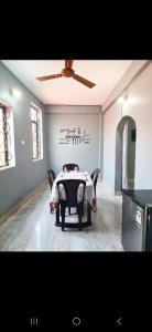 a room with a table with chairs and a ceiling fan at Jacksons Beach House Calangute in Calangute