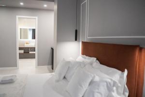 a bedroom with a bed with white sheets at Le Dimore del Centro in Bari