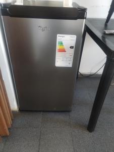 a refrigerator with a sticker on it next to a table at Un lugar perfecto in Juana Koslay 
