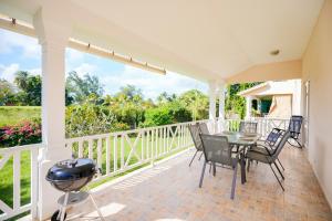 a patio with a table and chairs and a grill at Grand Gaube Golf Sea View Apartment in Mauritius +5 photos