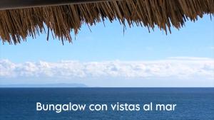a view of the ocean from a straw umbrella at Mandala Bungalows - Adults Only in Los Caños de Meca