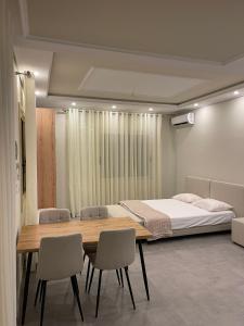a bedroom with a bed and a table and chairs at Oasis in Vlorë
