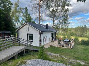 a white tiny house with a wooden deck at Modern Lakeside Hideaway in Örebro