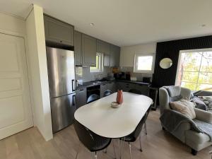 a kitchen with a white table and a white table at Modern Lakeside Hideaway in Örebro