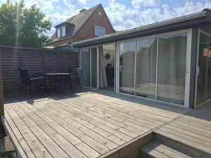 a wooden deck with a table and chairs on it at Privat gästhus med egen trädgård in Kävlinge
