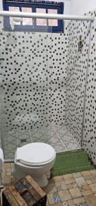 a bathroom with a white toilet in a shower at Chalé Pocinho in Tiradentes