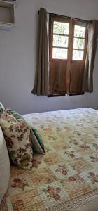 a bedroom with a bed with a window at Chalé Pocinho in Tiradentes +2 photos