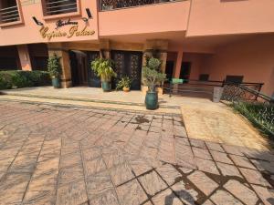 a building with potted plants in front of it at Appartement 6 personnes piscine hivernage Marrakech in Marrakesh