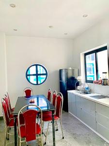 a kitchen with a dining table and red chairs at Anna Belle - Henry Hotel Đồi Rồng chuỗi HPT Home Hải Phòng in Hai Phong