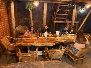 a group of people sitting around a wooden table at Serengeti Home in Arusha