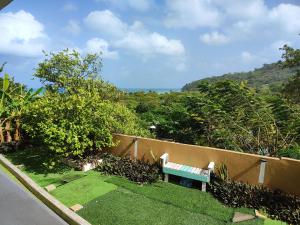 a bench sitting in a yard next to a fence at EcoApartamentos Sunset Life in Providencia