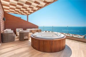 a large room with a hot tub on a balcony at Qlusive Hotel in Kusadası