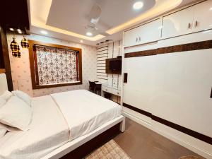a bedroom with a white bed and a window at 2bed 2bath 2AC kitchen , Puri , Near Beach, Homestay at Ananya Palm Beach Apartment in Puri