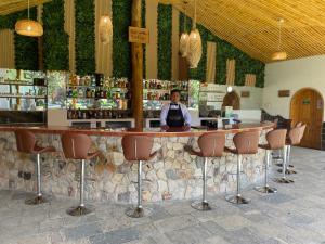 a man standing at a bar in a restaurant at Gran Kuntur Wasi Hotel Casa y Campo in Cajamarca