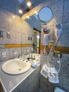 a bathroom with a sink with a hair dryer and a mirror at Gran Kuntur Wasi Hotel Casa y Campo in Cajamarca