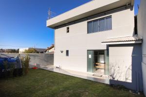 a white house with a green door and a yard at Lou Suítes 11 - City Mood, estadia leve in Guarapuava
