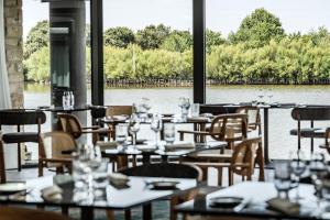 a restaurant with tables and chairs next to a river at Thalazur Carnac in Carnac