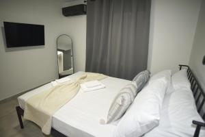 a bedroom with a white bed with a mirror at Paul's Houses 2 in Drama