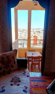 a room with a table and a view of a balcony at Palais AL Firdaous in Fez