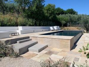 a swimming pool in a garden with a bench next to it at Casale Nostos in SantʼAgata sui Due Golfi