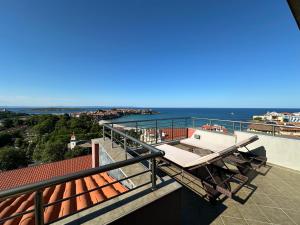 a balcony with a table and a view of the ocean at Family Hotel Radiana in Sozopol