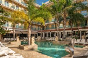 a hotel with a swimming pool in front of a building at Hotel la Palmera & Spa in Lloret de Mar