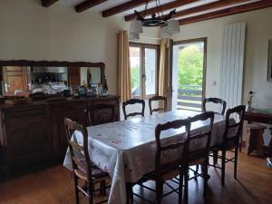 a dining room with a table with chairs and a mirror at Chalet Mireneige, charme et confort face au Mont Blanc in Combloux