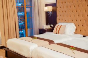two beds in a hotel room with flowers on them at 泊悦国际大酒店 BoYue Hotel in Addis Ababa Bole International Airport +88 photos