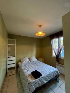 Un dormitorio con una cama con un edredón blanco. en Charmant bas de villa avec jardin, en La Ciotat