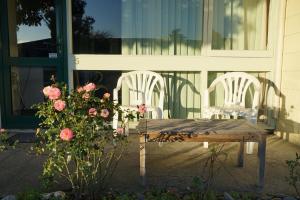 a wooden table with two chairs and flowers in front of a building at Tui Lodge Motel in Christchurch