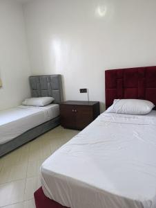 una camera con due letti e un comodino tra loro di familial simple pratique ad Agadir