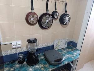 una cucina con pentole e padelle appese al muro di familial simple pratique ad Agadir