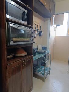 una cucina con forno a microonde in cima a un armadio di familial simple pratique ad Agadir Altre 3 foto