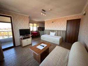 a living room with a couch and a tv at Family Hotel Radiana in Sozopol