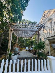 a wooden pergola with chairs and chairs on a patio at Orleans Holiday House in Orleans +23 photos